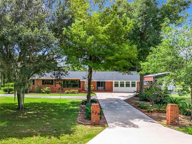 ranch-style house with brick siding, roof with shingles, driveway, and a front yard