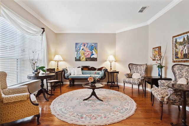 sitting room with hardwood / wood-style floors and ornamental molding