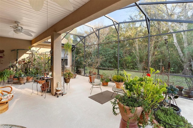 view of patio with ceiling fan and glass enclosure