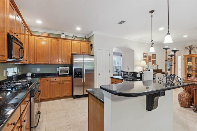 kitchen featuring light tile patterned flooring, dark stone countertops, hanging light fixtures, a center island, and stainless steel appliances