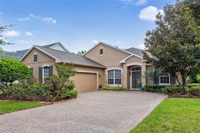 single story home featuring a garage and a front yard