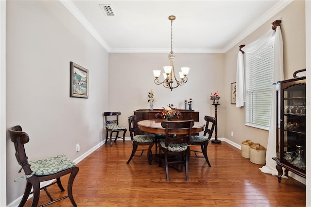 dining space with a notable chandelier, crown molding, and hardwood / wood-style floors