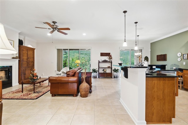 kitchen with pendant lighting, ornamental molding, a kitchen island with sink, and light tile patterned floors