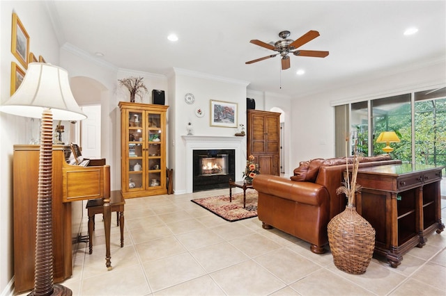 tiled living room with ceiling fan and ornamental molding