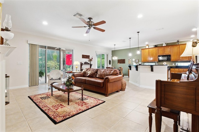 tiled living room with ornamental molding and ceiling fan