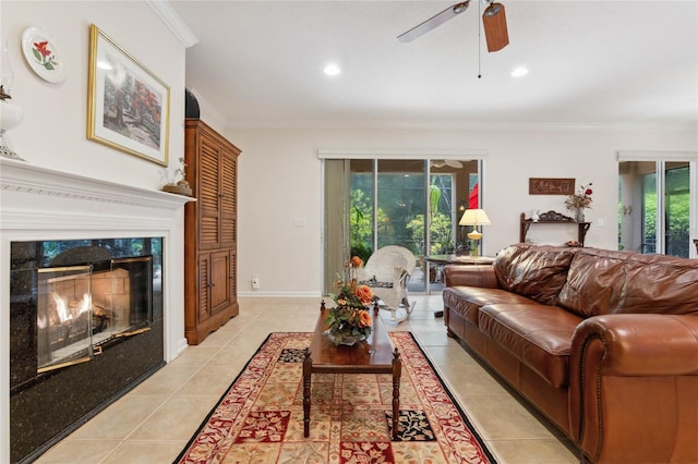 living room featuring crown molding, light tile patterned floors, ceiling fan, and a high end fireplace