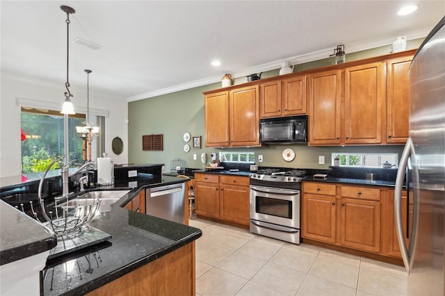 kitchen featuring appliances with stainless steel finishes, ornamental molding, decorative light fixtures, dark stone counters, and a chandelier