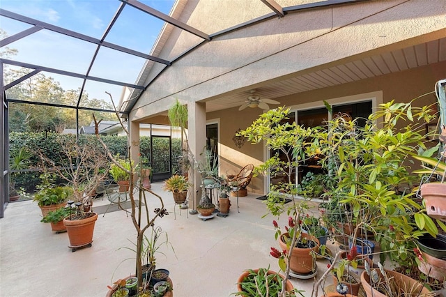 view of patio featuring ceiling fan and glass enclosure