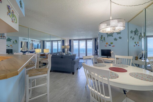 dining area with expansive windows, a chandelier, and a textured ceiling