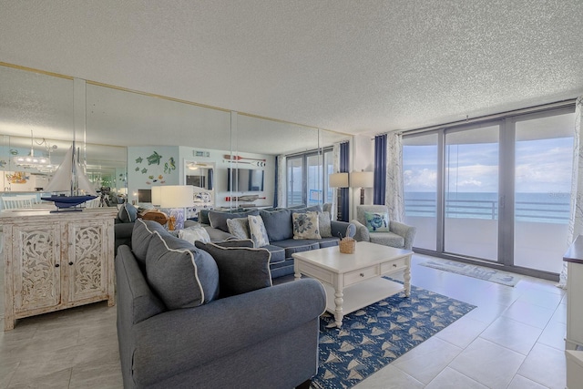 living room featuring a water view, expansive windows, and a textured ceiling