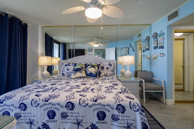 bedroom with a closet, ceiling fan, and a textured ceiling