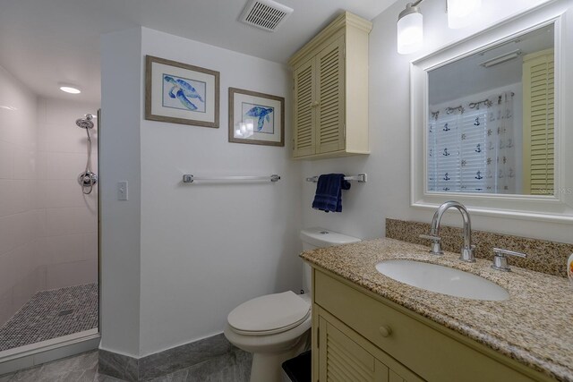 bathroom featuring tile patterned floors, tiled shower, toilet, and vanity