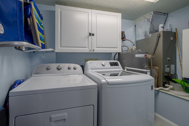 laundry room with a textured ceiling, cabinets, independent washer and dryer, and water heater