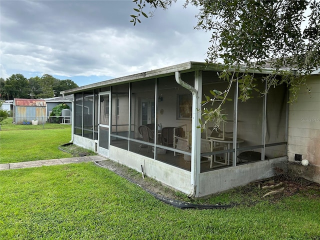 view of side of property featuring a sunroom and a yard