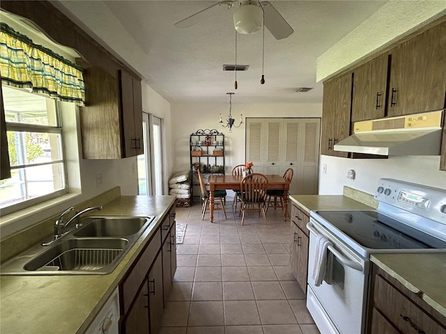 kitchen with ceiling fan with notable chandelier, light tile patterned floors, sink, white electric range oven, and hanging light fixtures