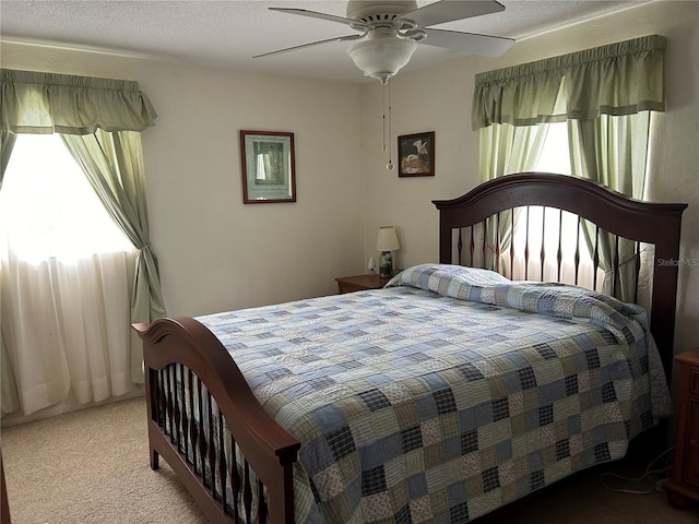 carpeted bedroom featuring a textured ceiling and ceiling fan