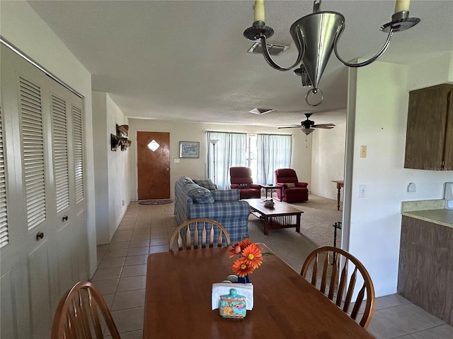 tiled dining room featuring a textured ceiling and ceiling fan