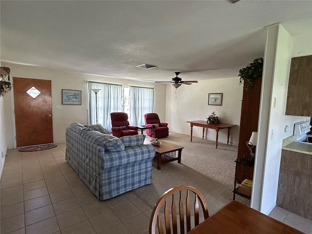 living room with a textured ceiling, carpet flooring, and ceiling fan