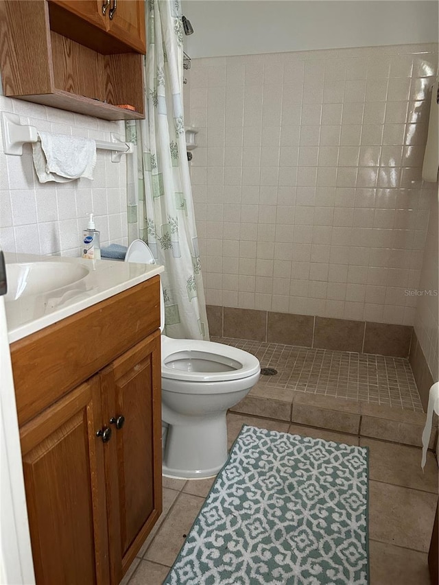 bathroom featuring a shower with shower curtain, tile patterned flooring, toilet, tile walls, and vanity