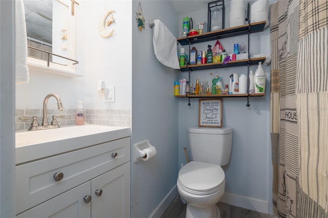 bathroom featuring vanity, toilet, backsplash, and walk in shower