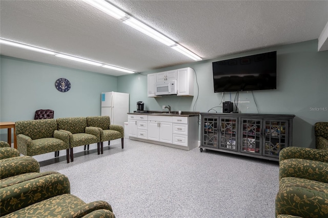 living room with a textured ceiling and sink