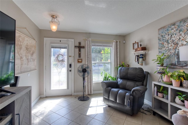 doorway to outside with a textured ceiling and light tile patterned floors