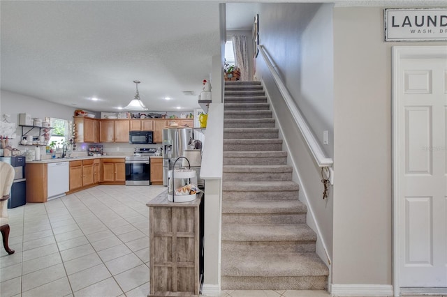 stairway with tile patterned flooring, sink, and a textured ceiling