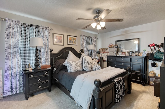 bedroom with a textured ceiling, light colored carpet, and ceiling fan