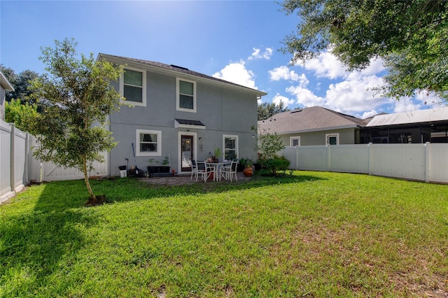 back of property with a yard and a patio