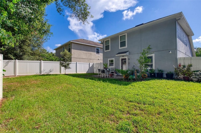 rear view of house with a lawn and a patio area