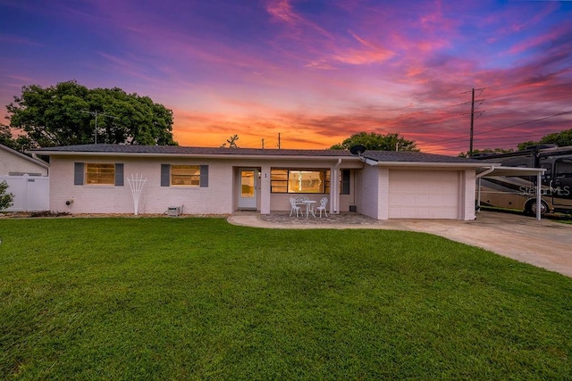 ranch-style house featuring a garage and a yard