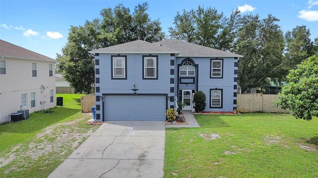 view of front of home with cooling unit, a garage, and a front lawn