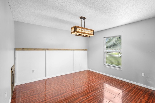 tiled spare room featuring a textured ceiling