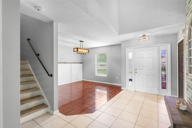 tiled foyer entrance with a textured ceiling