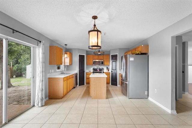 kitchen featuring stainless steel appliances, a kitchen island, sink, hanging light fixtures, and light tile patterned flooring