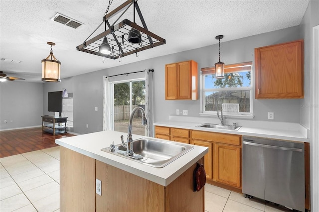 kitchen with light hardwood / wood-style flooring, a center island with sink, sink, ceiling fan, and stainless steel dishwasher