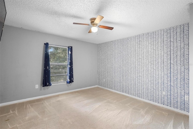 unfurnished room featuring a textured ceiling, ceiling fan, and carpet floors