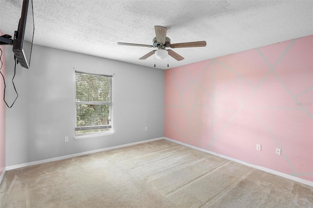 unfurnished room with a textured ceiling, ceiling fan, and carpet floors