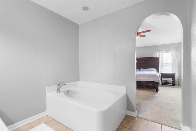 bathroom with ceiling fan, tile patterned floors, and a bathtub