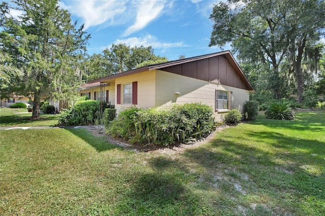 view of property exterior featuring board and batten siding and a lawn