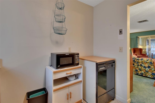 kitchen featuring light countertops, visible vents, white cabinets, light carpet, and black appliances