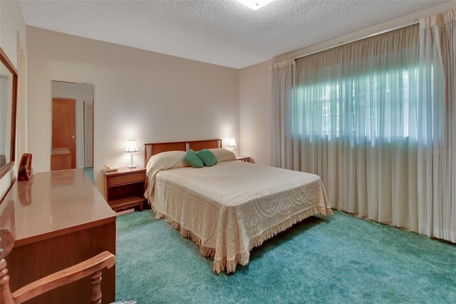 bedroom with a textured ceiling and carpet