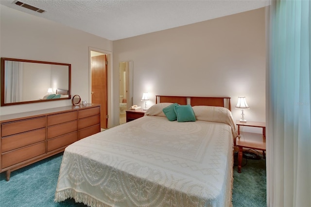 bedroom featuring visible vents, dark carpet, and a textured ceiling