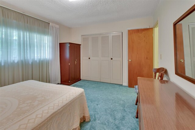 carpeted bedroom featuring a closet and a textured ceiling