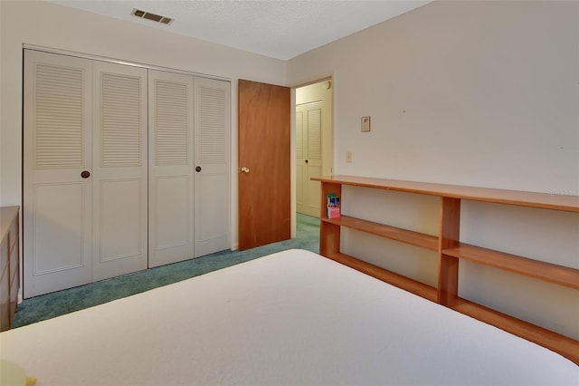 bedroom with carpet, a closet, visible vents, and a textured ceiling