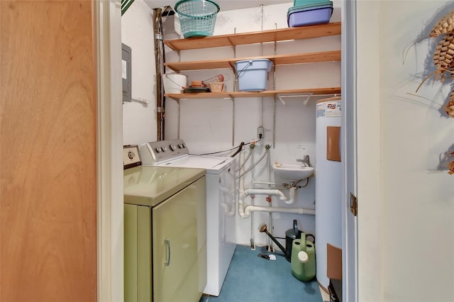 washroom featuring laundry area, water heater, a sink, and washer and clothes dryer