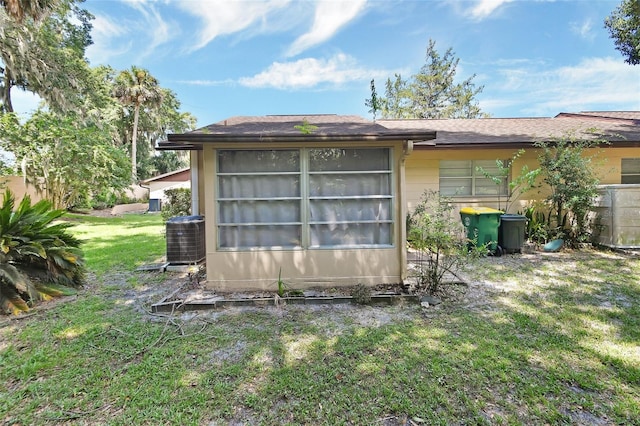 rear view of house with a yard and cooling unit