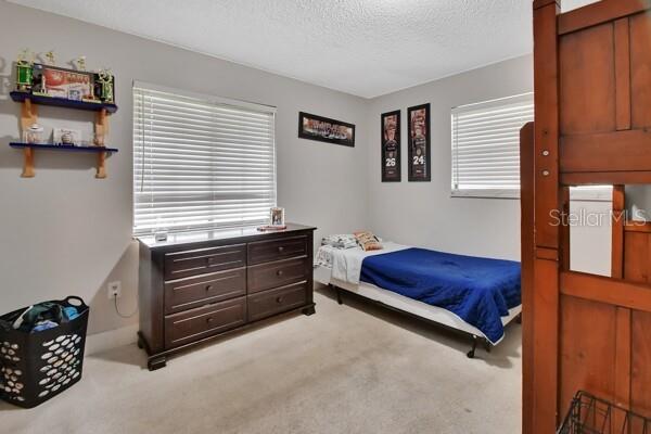 carpeted bedroom with a textured ceiling