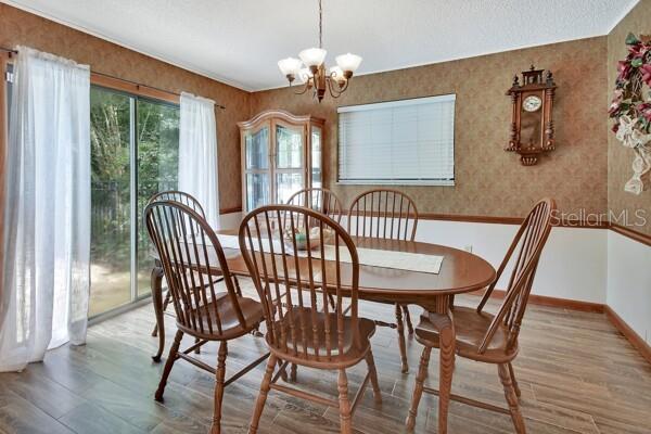 dining space with an inviting chandelier and hardwood / wood-style flooring