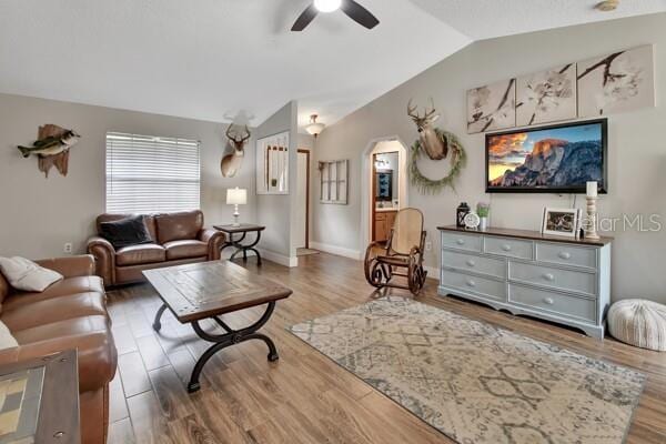 living room featuring lofted ceiling, ceiling fan, and hardwood / wood-style flooring